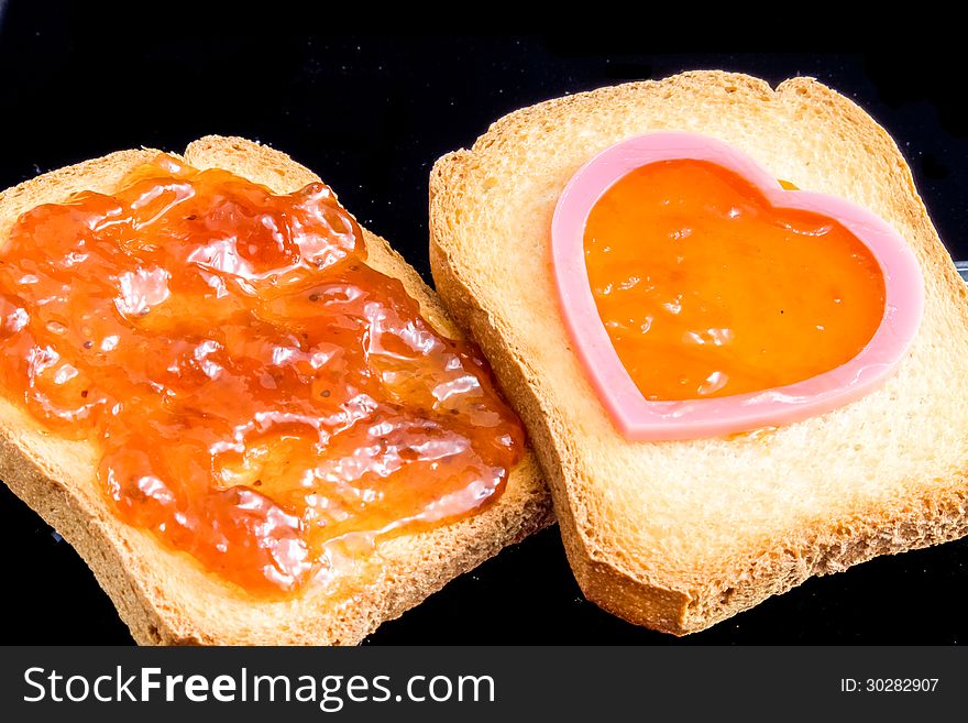 Jam, plastic heart and bread for the breakfast