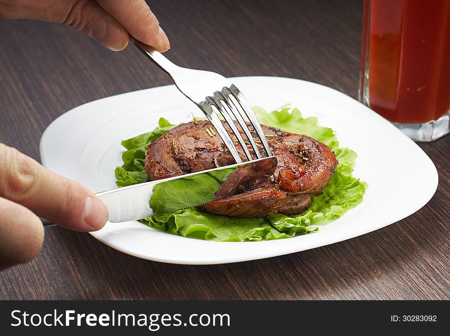 Cutting Grilled Steak With Knife On White Plate