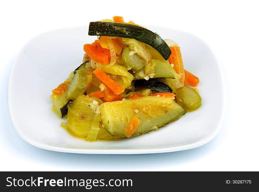 Ragout with Zucchini, Carrot, Leek and Bell Pepper on Square White Plate isolated on white background