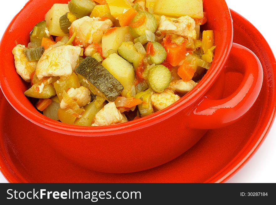 Vegetables and Chicken Ragout with Zucchini, Potato, Carrot, Bell Pepper, Tomatoes, Cabbage and Leek in Red Bowl closeup
