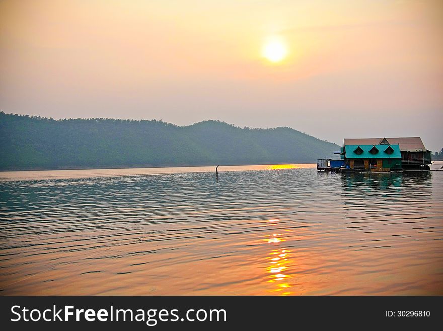 Sun set in a lake with floating wooden house. Sun set in a lake with floating wooden house