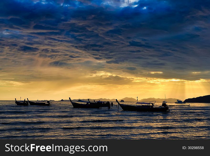 Ocean coast cloudy colorful sunset with fishing boats