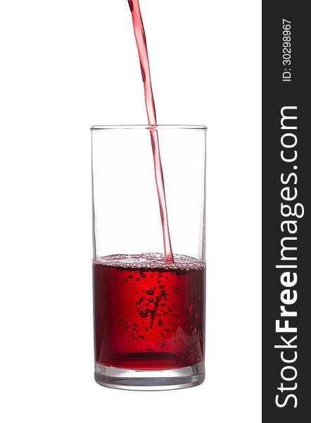 Stream of juice flows in a glass, isolated on white