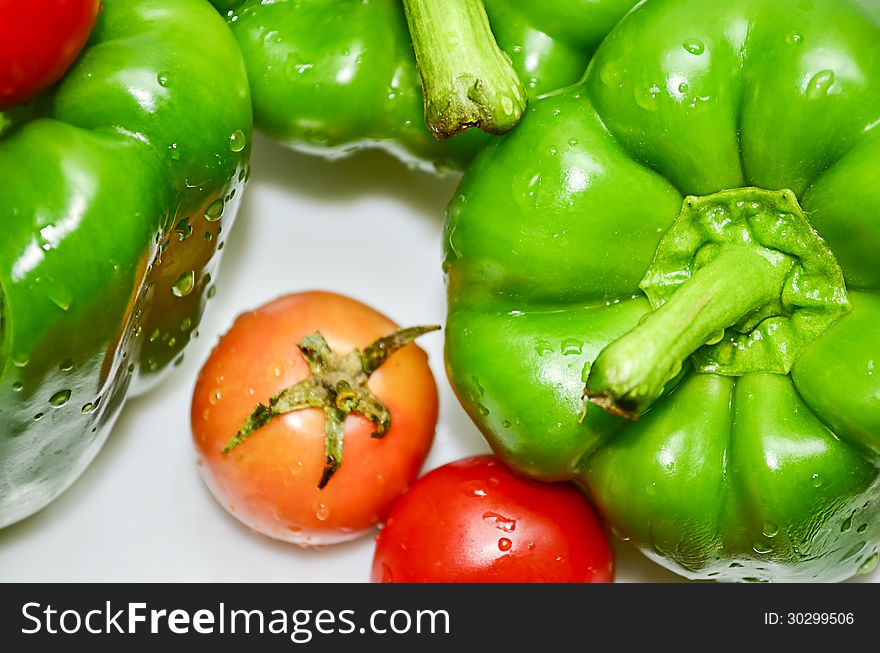 Green capcicum chilli and tomato with water drops on it