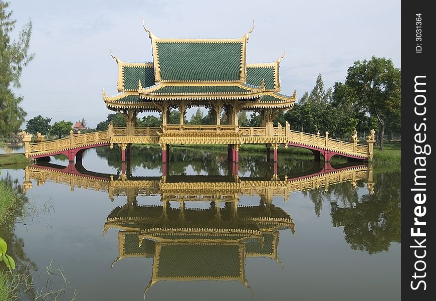 Covered bridge over a canal with traditional Thai architecture in Muang Boran, Samut Prakan, Thailand. The whole bridge reflected in the water. Covered bridge over a canal with traditional Thai architecture in Muang Boran, Samut Prakan, Thailand. The whole bridge reflected in the water.