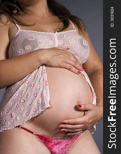Pregnant woman holding hands on her belly