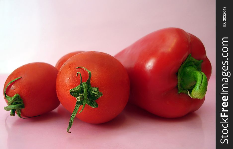 Tomatoes and red pepper over pink background