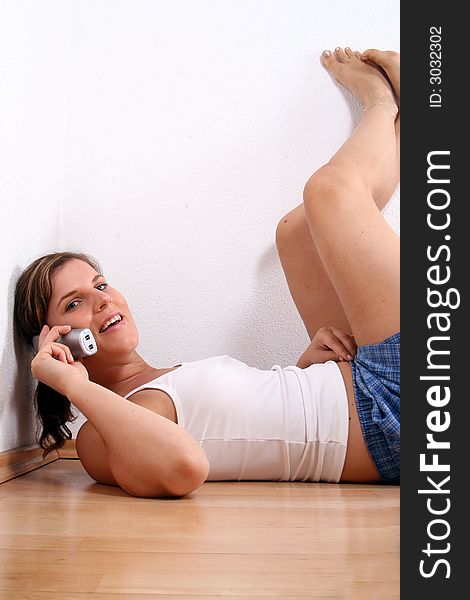 A young woman is chatting on the phone in her apartment!. A young woman is chatting on the phone in her apartment!