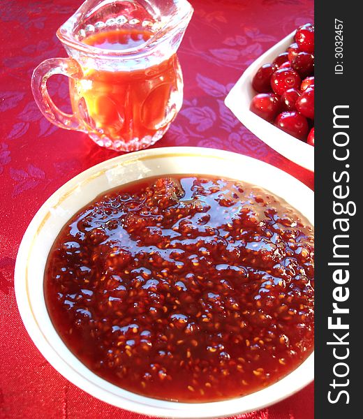 Fresh cherry in bowl, raspberry cooking and beverage on table. Fresh cherry in bowl, raspberry cooking and beverage on table