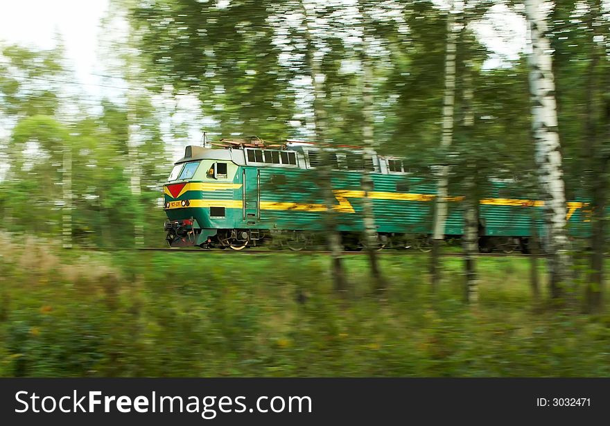A passanger locomotive moving through a forest on a sunny day. A passanger locomotive moving through a forest on a sunny day.