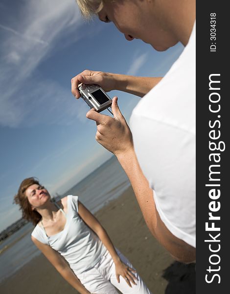 Young couple on the beach taking pictures