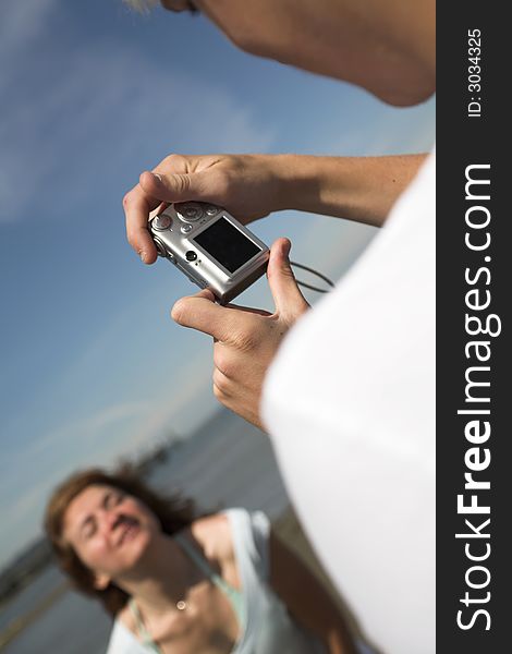 Young couple on the beach taking pictures