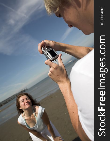 Young couple on the beach taking pictures