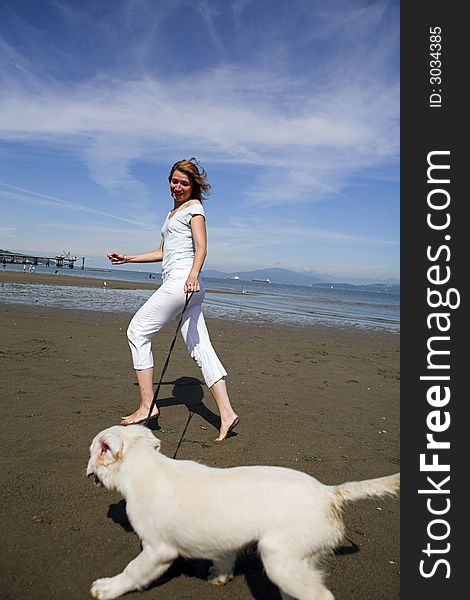 Woman running with her dog on the beach