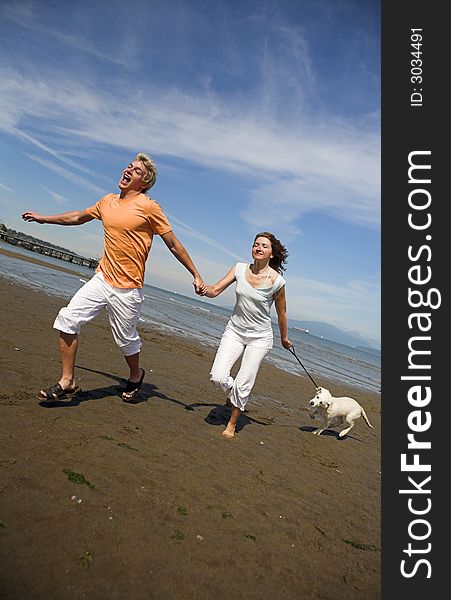 Young couple on the beach with dog in vancouver