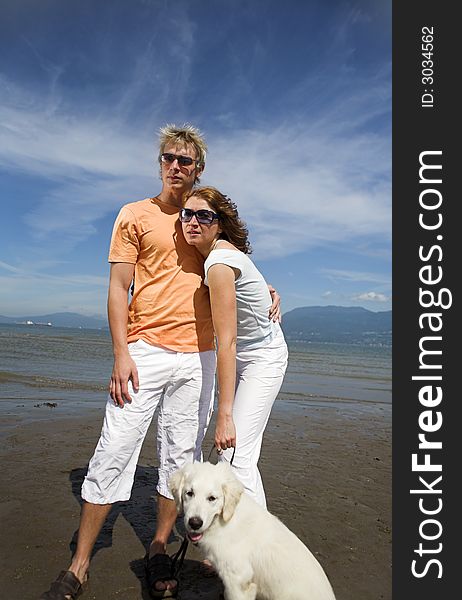 Young couple on the beach with dog in vancouver