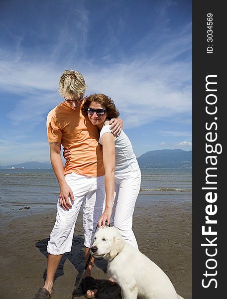 Young couple on the beach with dog in vancouver