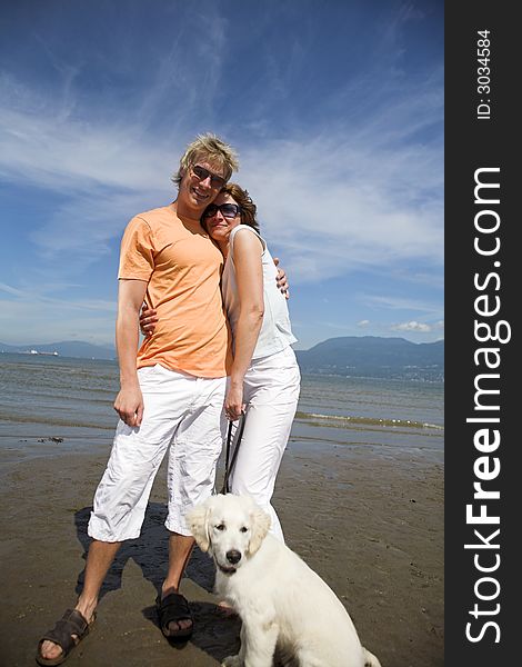 Young couple on the beach with dog in vancouver