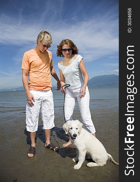 Young couple on the beach with dog in vancouver