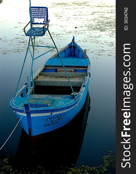 Blue and small fishing boat with a small deer-stand. Blue and small fishing boat with a small deer-stand.