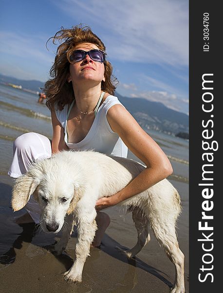 Woman portrait petting her dog on the beach