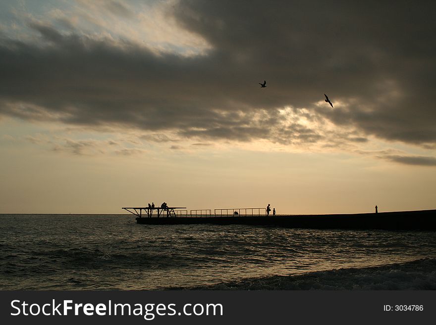 Sea; moorage, mooring line; pier; wave; sky; gull, seagull, mew. Sea; moorage, mooring line; pier; wave; sky; gull, seagull, mew