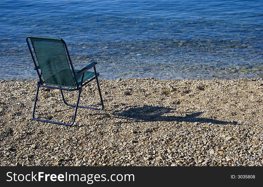 Green armchair on the beach