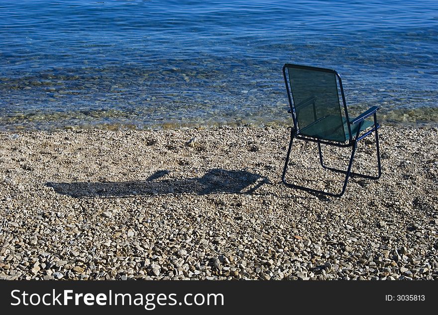 Chair near the blue waves. Chair near the blue waves