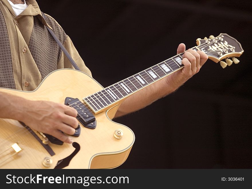 Close-up of a guitar player during a performance. Close-up of a guitar player during a performance.