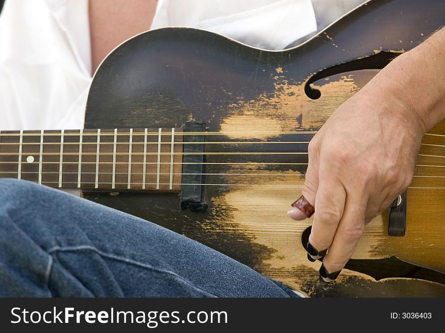 Close-up of a guitar player during a performance. Close-up of a guitar player during a performance.