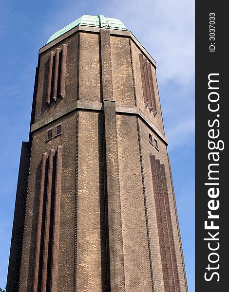 A water tower with a copper roof against a blue sky