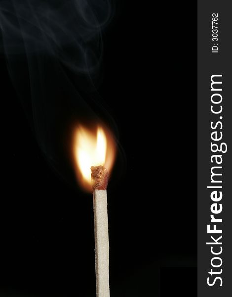 Burning Flame On A Single Matchstick On A Black Background. Burning Flame On A Single Matchstick On A Black Background