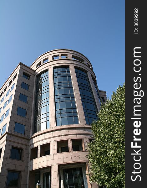 The curved glass front of a modern office building. The curved glass front of a modern office building