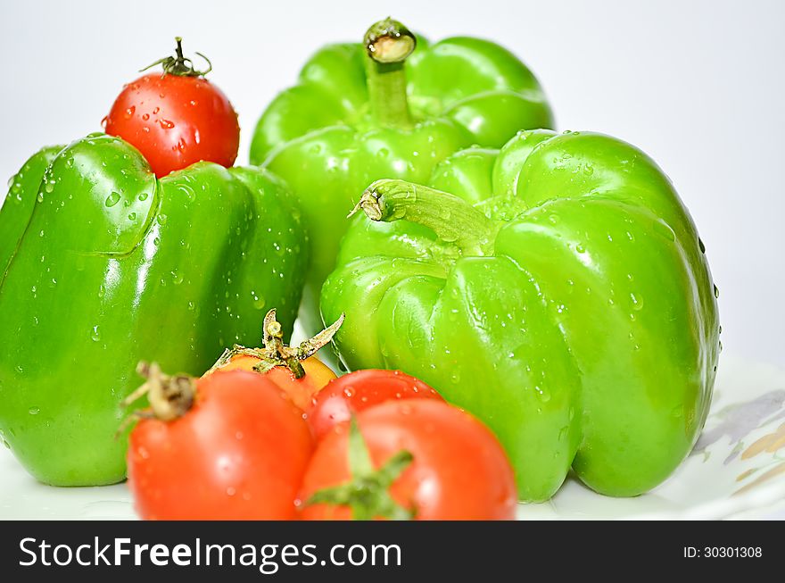 Green capcicum chilli and tamato with water drops on it