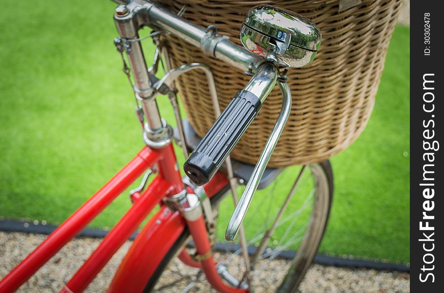 Vintage a red bicycle with weaving basket infront