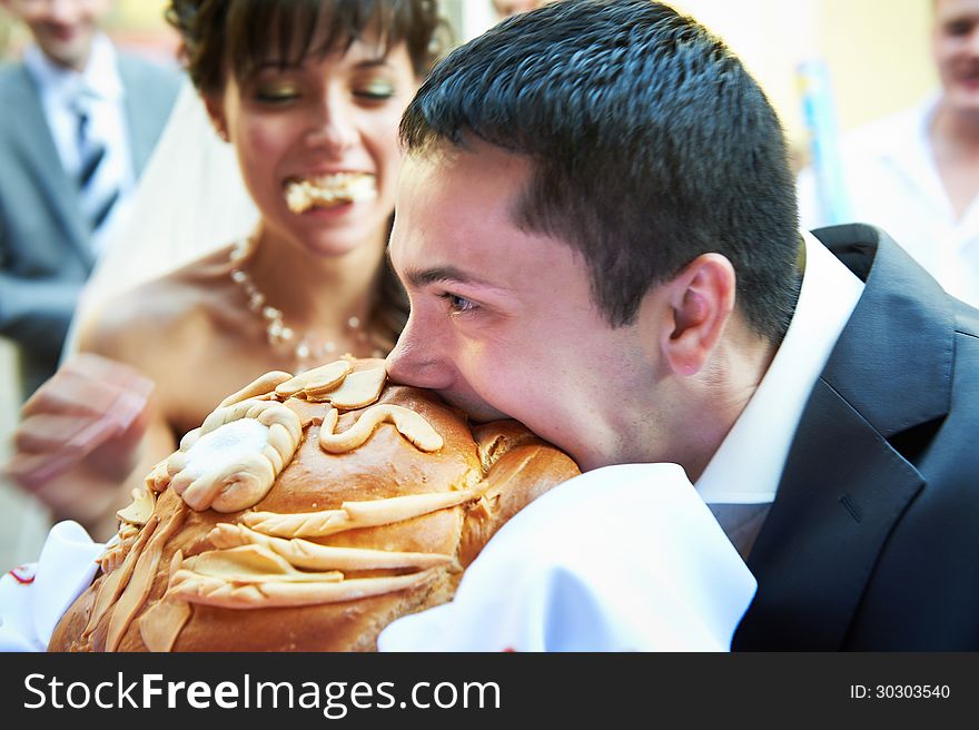 Groom Biting Loaf Of Bread