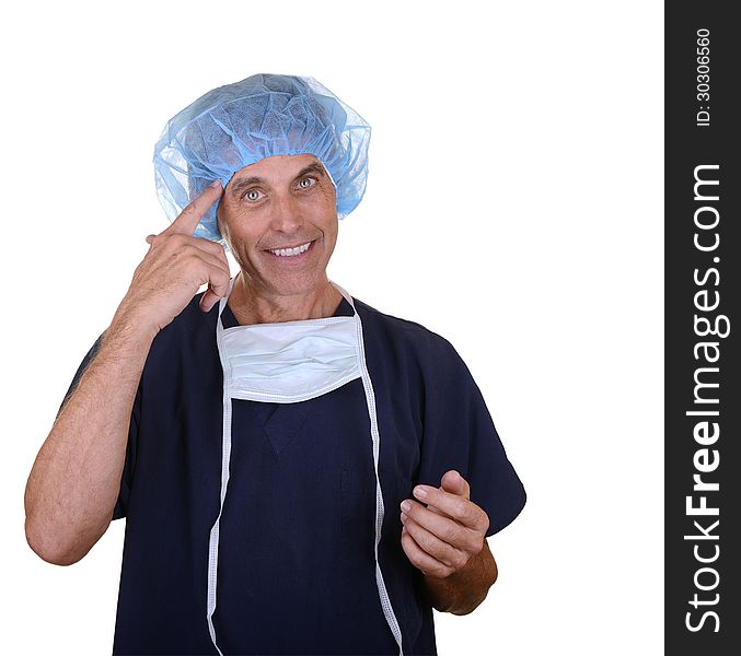 Smiling surgeon wearing navy blue scrubs, hair cover, and mask hanging down pointing at himself. Smiling surgeon wearing navy blue scrubs, hair cover, and mask hanging down pointing at himself