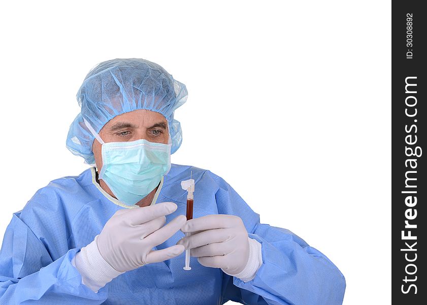 Healthcare worker in blue sterile gown, cap, mask, and gloves holding a syringe of blood isolated on white. Healthcare worker in blue sterile gown, cap, mask, and gloves holding a syringe of blood isolated on white
