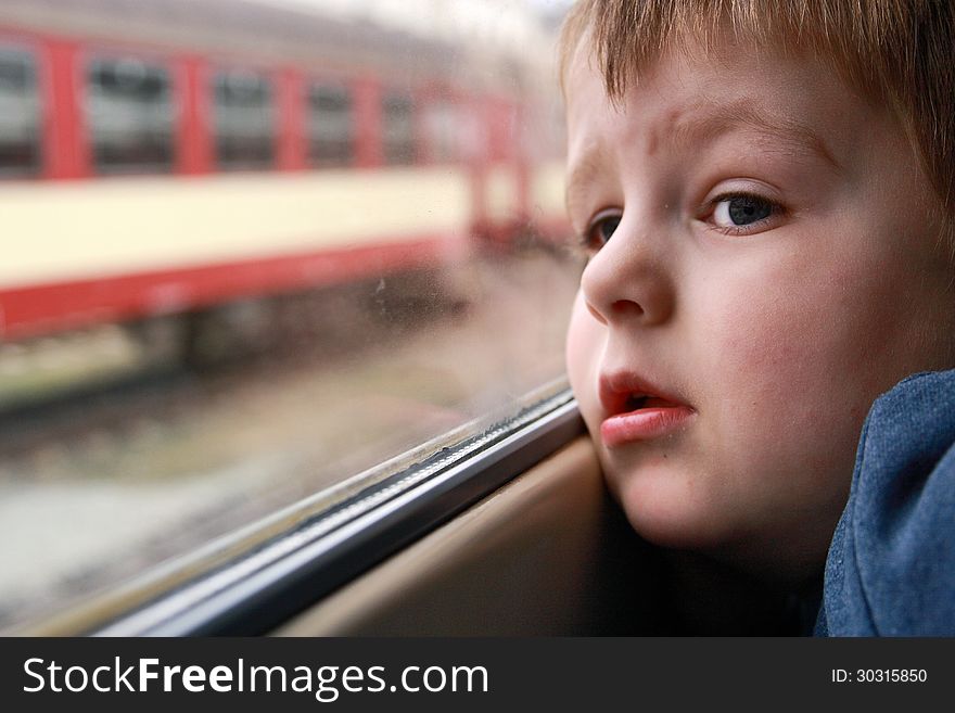 Little boy looking out the train window