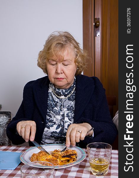 Elderly woman at table eating