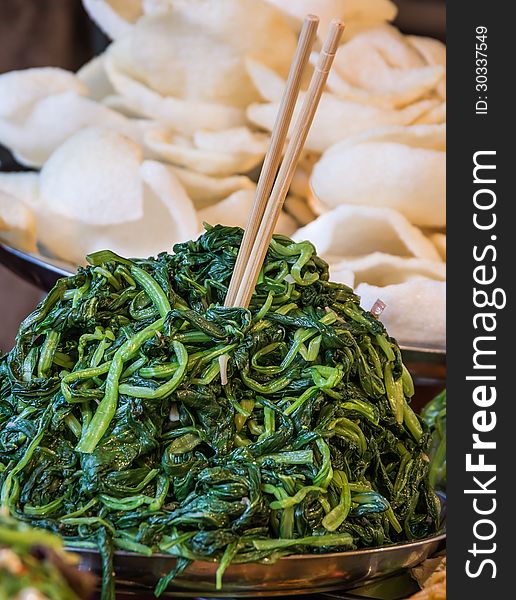 Close up of cooked vegetables with shrimp crackers in defocused background. Close up of cooked vegetables with shrimp crackers in defocused background.