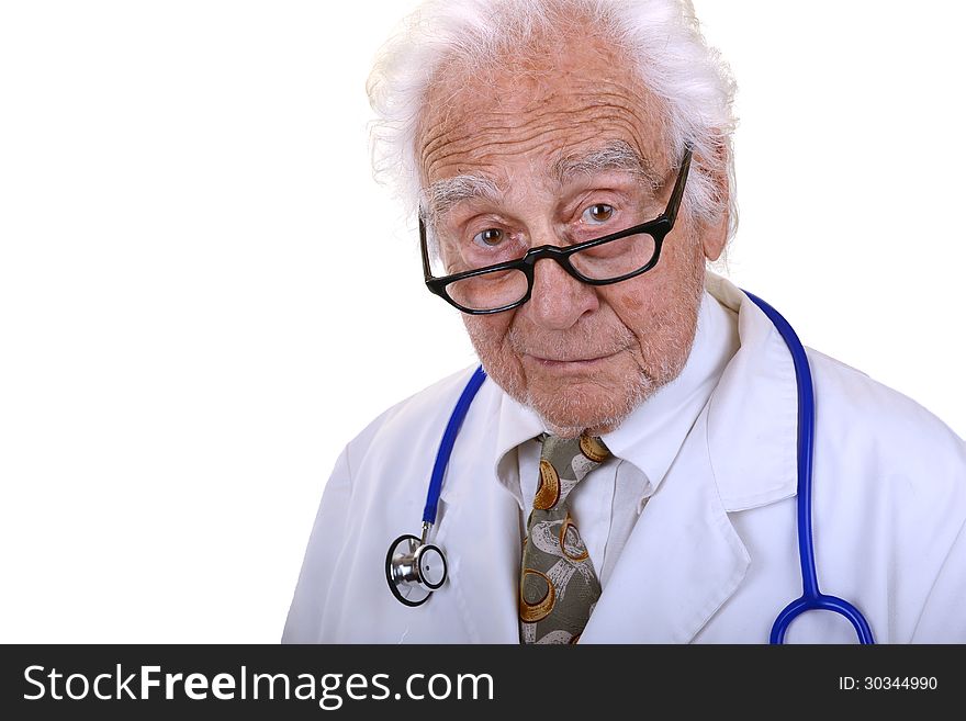 Senior doctor with gray hair wearing a white lab coat, glasses, and a blue stethoscope with kind look on his face isolated on white. Senior doctor with gray hair wearing a white lab coat, glasses, and a blue stethoscope with kind look on his face isolated on white