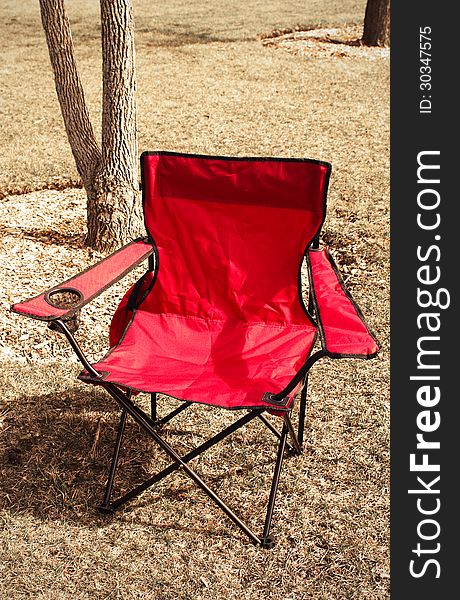 Red camping chair in the park