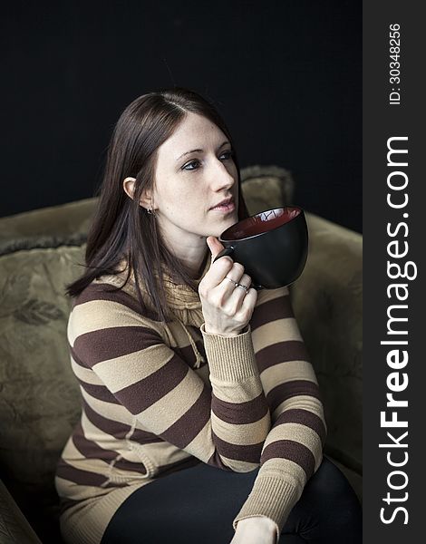 Beautiful young woman with brown hair and eyes holding a black coffee cup. Beautiful young woman with brown hair and eyes holding a black coffee cup.