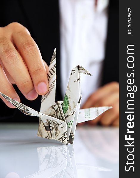 Business man hand holding origami paper cranes, money concept