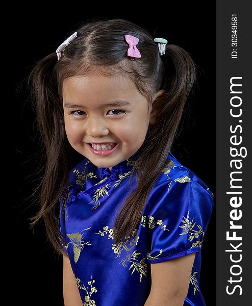 Smiling portrait of a little Philippino girl in a blue silk dress