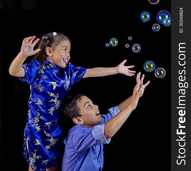 brother and sister children playing and catching bubbles. brother and sister children playing and catching bubbles