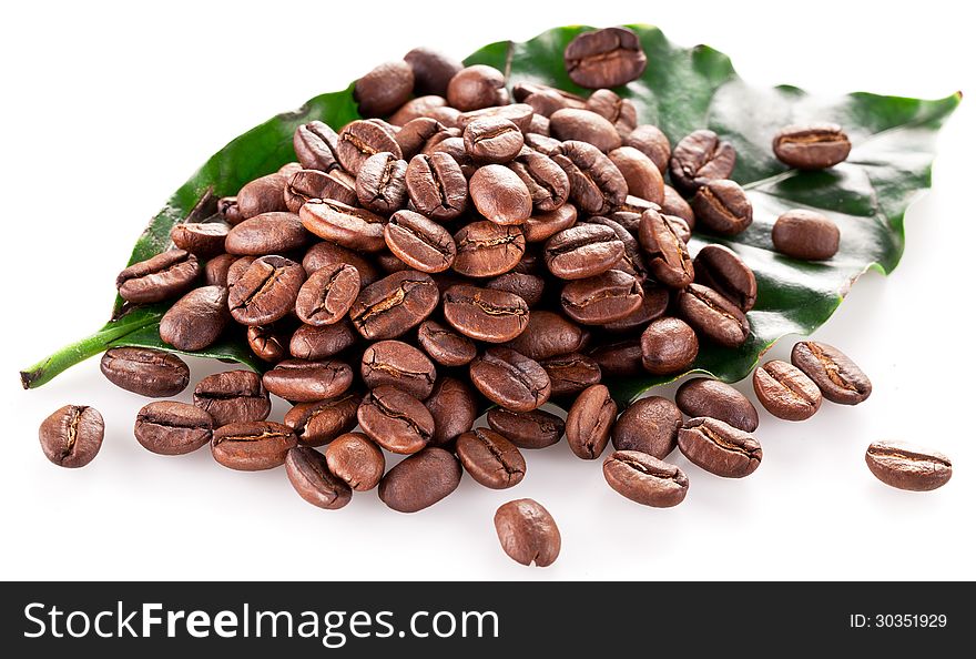 Coffee beans on leaf. Closeup snapshot on a white background.