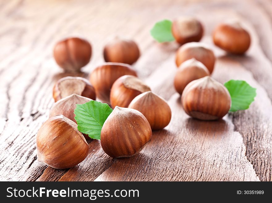 Filberts with leaves on a wooden table. Close-up shot. Filberts with leaves on a wooden table. Close-up shot.