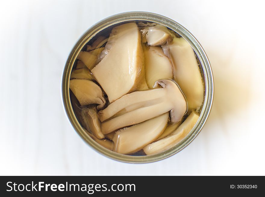 Open tin can of sliced mushrooms. Open tin can of sliced mushrooms